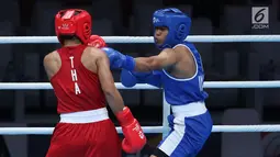 Petinju putri Indonesia, Huswatun Hasanah (kaus biru) melempaskan pukulan ke arah Sudaporn Seesondee (Thailand) pada semifinal kelas ringan 60kg putri Asian Games 2018 di JIEXPO Kemayoran, Jumat (31/8). Huswatun kalah. (Liputan6.com/Helmi Fithriansyah)