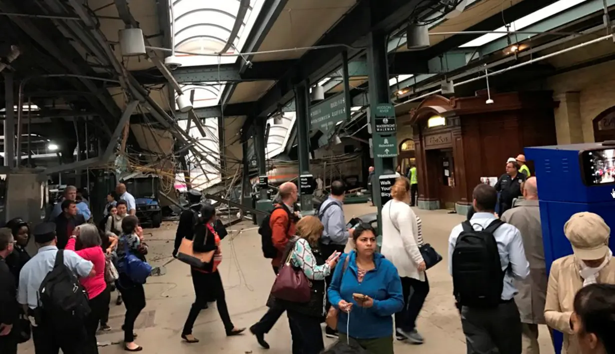 Calon penumpang mengamati kereta komuter yang tergelincir dan menabrak peron Stasiun Hoboken, New Jersey, Kamis (29/9). Saksi mata mengatakan kereta tidak mengurangi kecepatan saat mendekati stasiun. (Courtesy of David Richman via REUTERS)