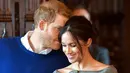 Pangeran Harry terlihat membisikkan sesuatu kepada sang tunangan, Meghan Markle ketika keduanya menjalani kunjungan ke Cardiff Castle, Wales, Kamis (18/1). Entah apa yang dibisikkan, namun momen manis itu membuat Meghan tertawa. (BEN BIRCHALL/POOL/AFP)