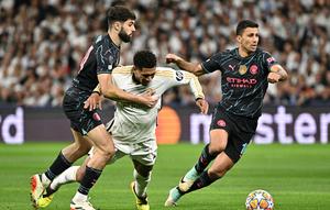 Gelandang Man City, Rodri (kanan) ketika merebut bola dari gelandang Real Madrid, Jude Bellingham, dalam leg pertama perempat final Liga Champions 2023/2024 di Santiago Bernabeu, Rabu (10/4/2024) dini hari WIB. (JAVIER SORIANO / AFP)