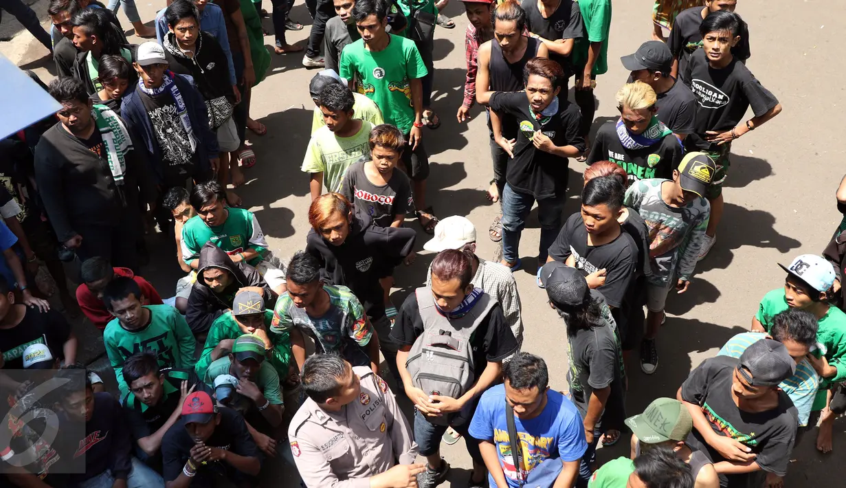 Ratusan suporter klub Persebaya duduk antri mengambil makanan di kawasan GOR Padjajaran, Bandung, Sabtu (7/1). Seiring pelaksanaan kongres PSSI 2017, pendukung Persebaya Surabaya berkumpul di GOR Padjajaran, Bandung. (Liputan6.com/Helmi Fithriansyah)