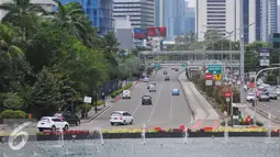 Sejumlah mobil melintas di Kawasan Bundaran HI, Jakarta, Rabu (15/2). Libur Pemilihan Gubernur DKI membuat sejumlah ruas jalan di Jakarta nampak lengang. (Liputan6.com/Angga Yuniar)