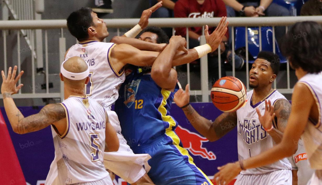 Pemain Satya Wacana, Musthofa Ramadhan #12 dihadang para pemain CLS Knight pada perempat final Playoffs Indonesia  Basket League (IBL) di Britama Arena, Jakarta, Selasa (17/5/2016). (Bola.com/Nicklas Hanoatubun)