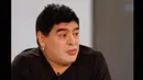 Dengan bibir tebal berwarna merah, wajah putih berkat pulasan bedak dan anting yang menggantung di telinga kanan, Diego Armando Maradona terlihat lebih muda. Foto diambil pada 1 Maret 2015. (REUTERS/Jorge Silva)