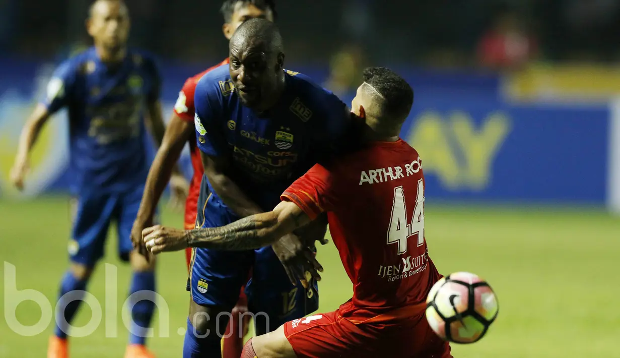 Striker Persib Bandung, Carlton Cole, berusaha melewati pemain Arema FC, Arthur Cunha. Ketatnya penjagaan terhadap pergerakan Carlton Cole membuatnya gagal mencetak gol dalam pertandingan tersebut. (Bola.com/M Iqbal Ichsan).