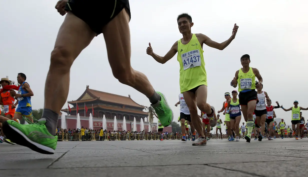 Peserta berlari melewati gerbang Tiananmen saat Beijing International Marathon di Beijing, China, Minggu (20/9/2015). Sekitar 30.000 pelari ikut ambil bagian dalam acara yang berlangsung tiap tahun. (REUTERS/Kim Kyung-Hoon)