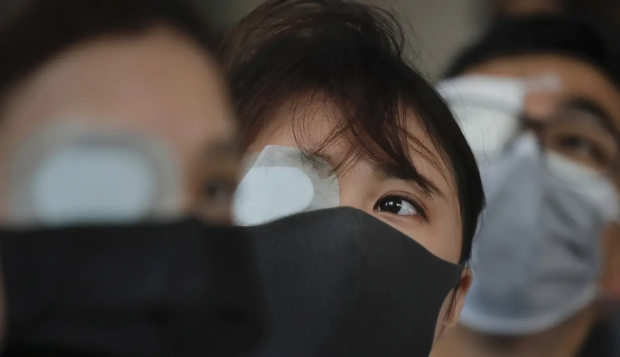 Seorang perawat mengenakan penutup mata dan masker mengambil bagian dalam protes terhadap kebrutalan polisi terhadap para pengunjuk rasa di sebuah rumah sakit di Hong Kong (13/8/2019). (AP Photo/Kin Cheung)