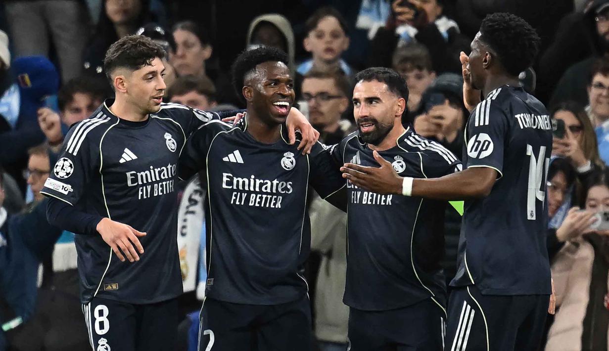 Penyerang Real Madrid, Vinicius Junior (kedua kiri) merayakan golnya pada pertandingan leg kedua 16 besar Liga Champions 2025/2026 melawan Manchester City di Etihad Stadium, barat laut Inggris, pada Selasa 17 Maret 2026 waktu setempat atau Rabu (18/3) dini hari WIB. Menang agregat 5-1 atas Manchester City, Real Madrid lolos ke perempat final Liga Champions 2025/2026. (Paul ELLIS/AFP)