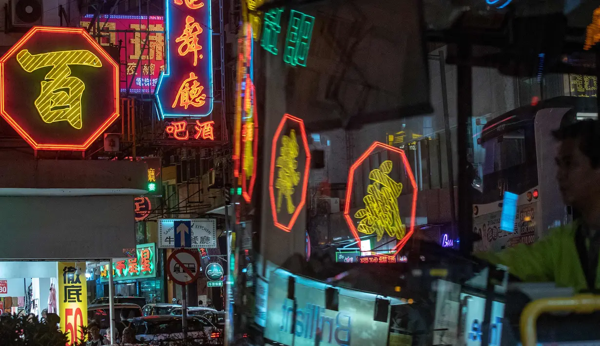 Sebuah bus melewati tanda-tanda neon 'Broadway Ballrooms' di Hong Kong (16/4). Wu Chi-kai merupakan salah satu pengrajin neon sign yang tersisa dari jenisnya di Hong Kong. (AFP Photo/Philip Fong)