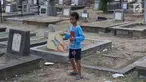 Seorang anak bermain layangan di TPU Menteng Pulo, Jakarta, Kamis (18/10). Padatnya pemukiman penduduk serta gedung bertingkat di kawasan tersebut menyebabkan anak-anak terpaksa bermain di tempat yang tidak semestinya. (Liputan6.com/Immanuel Antonius)