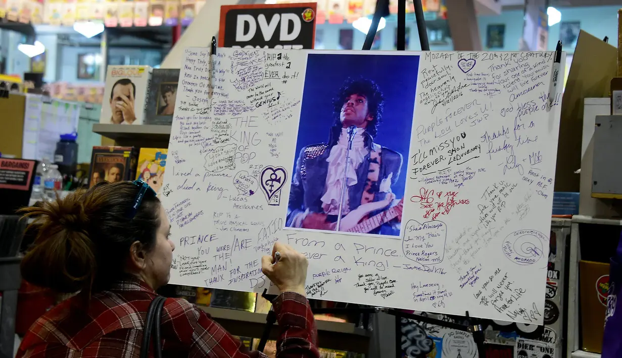 Penggemar menulis pesan yang didedikasikan untuk penyanyi legendaris dunia, Prince di Amoeba Records, Hollywood, Kamis (21/4). Prince ditemukan dalam posisi telentang dan keadaannya sudah tak bernafas di Paisley Park, Minnesota. (Frederic J. BROWN/AFP)