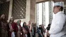 Kepala Protokol Masjid Istiqlal, Abu Hurairah bersama peserta Puteri Muslimah Asia 2018 saat tour Mesjid Istiqlal, Jakarta, Kamis (3/4). Masing masing negara mengutus tiga kontestan. Peserta berumur 15 sampai 25 tahun. (Liputan6.com/Faizal Fanani)