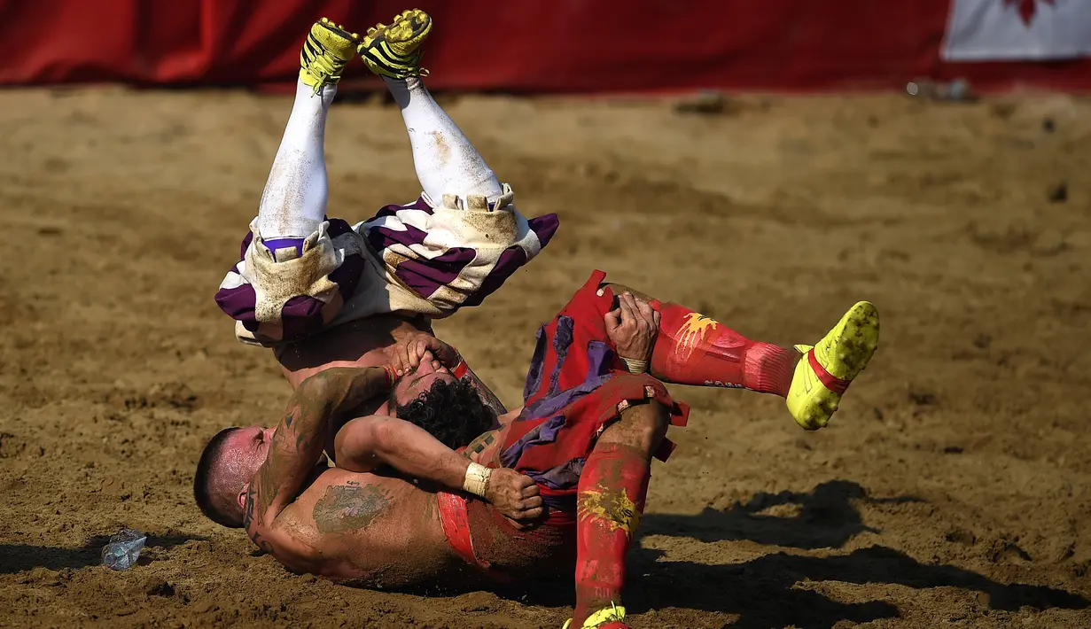 Pemain membanting lawannya saat pertandingan Calcio Storico Fiorentino di Piazza Santa Croce di Florence, Italia (24/6). Calcio Storico berasal dari olahraga Romawi kuno, Haspartum. (AFP Photo/Filippo Monteforte)