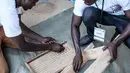 Sejumlah petugas menyiapkan kelereng yang akan digunakan untuk pemilihan Presiden Gambia di distrik Tallinding, Serekunda, Gambia (30/11). Bedanya hanya terdapat pada alat yang digunakan dan cara perhitungan yang unik. (AFP/Marco Longari)