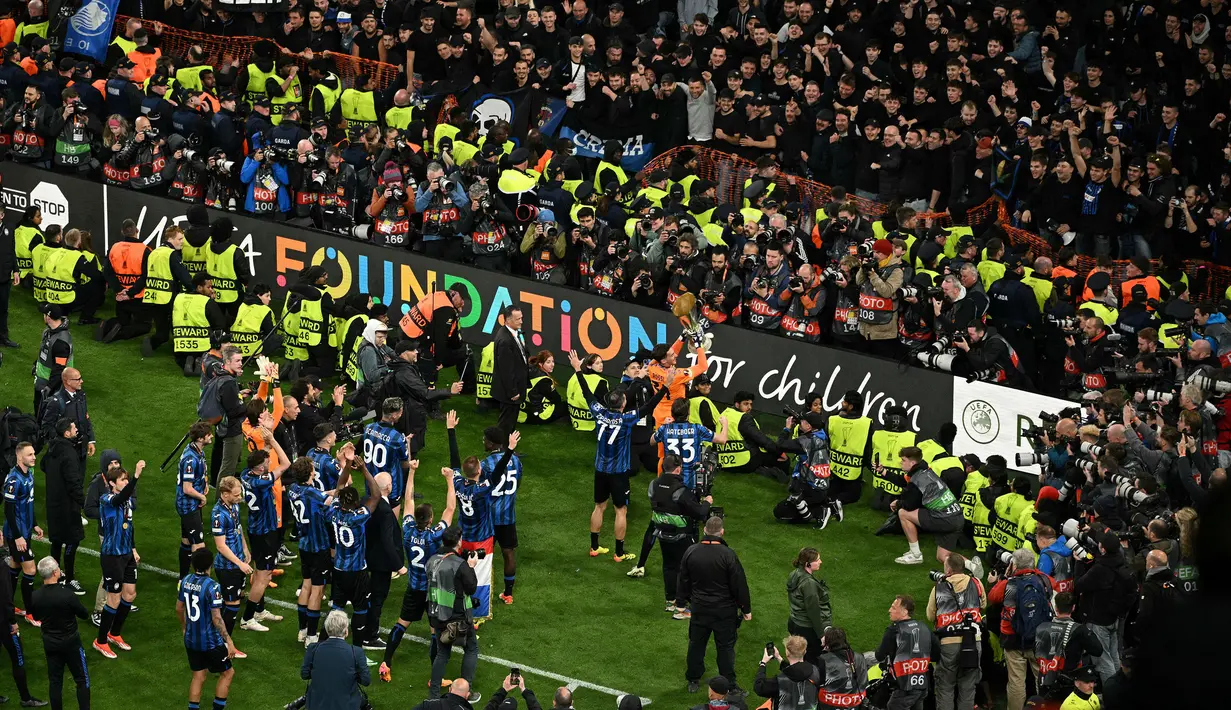 Pemain Atalanta merayakan gelar juara Liga Europa 2023/2024 bersama fans setelah mengalahkan Bayer Leverkusen dengan skor 3-0 pada laga final yang berlangsung di Dublin Arena, Irlandia, Kamis (23/05/2024) dini hari WIB. (AFP/Oli Scarff)