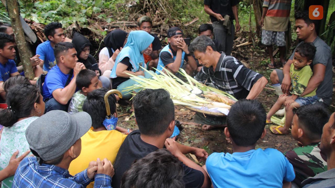 Warga kampung saat tengah melaksanakan ritual motolohuta atau memberi makan setan (Arfandi Ibrahim/Liputan6.com)