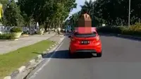 Pria telanjang diduga orang gila naik ke atas mobil yang dikendarai dokter di Jalan Jenderal Sudirman, Pekanbaru. (Liputan6.com/M Syukur)