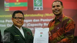 Ketua Umum PKB Muhaimin Iskandar (kiri) bersama Ketua Umum BUP, Blasius Pereira menunjukan hasil MoU usai penandantanganan kesepakatan antara PKB dengan BUP Partai Timor Leste di Gedung DPP PKB, Jakarta, Kamis (7/1). (Liputan6.com/Faizal Fanani)