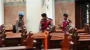 Sterilisasi gereja untuk menjamin rasa aman umat Kristiani dalam menjalankan ibadah menyambut Natal. Tampak dalam foto, personel dari regu penjinak bom kepolisian Indonesia memeriksa deretan kursi di dalam gereja selama operasi keamanan menjelang perayaan Natal di Katedral Bunda Maria Diangkat ke Surga atau Gereja Katedral Jakarta, Selasa 23 Desember 2025. (AP Photo/Tatan Syuflana)