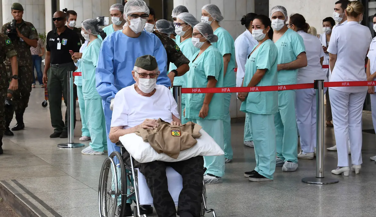 Veteran Perang Dunia II asal Brasil, Ermando Armelino Piveta meninggalkan Rumah Sakit Angkatan Bersenjata setelah pulih dari covid-19 di Brasilia, Selasa (14/4/2020). Kakek berusia 99 tahun itu dinyatakan sembuh dari virus Corona setelah dirawat selama delapan hari. (EVARISTO SA/AFP)
