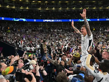 Gelandang Real Madrid, Toni Kroos (kanan) saat merayakan kemenangan bersama para suporter usai memenangi Liga Champions 2023/2024 melawan Borussia Dortmund di stadion Wembley, London, pada 1 Juni 2024. (Glyn KIRK/AFP)