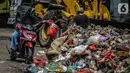 Pengendara motor membuang sampah di kolong tol Wiyoto Wiyono, Tanjung Priok, Jakarta, Selasa (5/11/2019). Sampah yang menumpuk  berasal dari sampah rumah tangga warga sekitar yang tidak memiliki tempat pembuangan sampah sementara.  (Liputan6.com/Faizal Fanani)