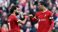 Penyerang Liverpool, Mohamed Salah, dan bek The Reds, Virgil van Dijk, merayakan keberhasilan mencetak gol ke gawang Everton dalam laga pekan kesembilan Liga Inggris 2023/2024 di Anfield, Sabtu (21/10/2023) malam WIB. Liverpool menang 2-0 dalam laga ini. (Paul ELLIS / AFP)