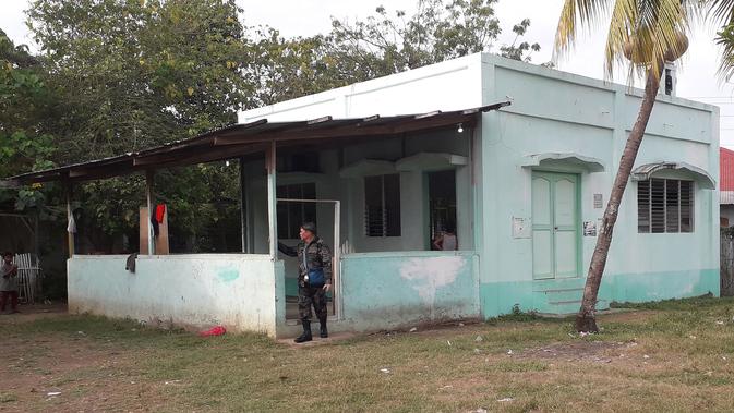 Seorang petugas kepolisian berdiri di pintu masuk sebuah masjid setelah serangan granat di Zamboanga, Filipina selatan, Rabu (30/1). Akibat serangan granat tersebut, dua orang tewas dan empat lainnya luka-luka. (Photo by STR / AFP)