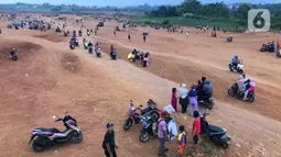 Warga beraktivitas di tanah lapang di kawasan Cipayung, Depok, Jawa Barat, Kamis (11/6/2020). Kurang tegasnya sanksi serta minimnya kesadaran masyarakat akan protokol kesehatan terkait covid-19 menyebabkan kawasan itu menjadi tempat berkerumun warga setiap sore hari. (Liputan6.com/Immanuel Antonius)