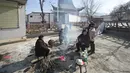 Orang-orang berkumpul di sekitar api unggun untuk menghangatkan diri di luar masjid setempat setelah gempa bumi di desa Gaoli di Kabupaten Jishishan di provinsi Gansu, barat laut China, Rabu (20/12/2023). (Pedro Pardo / AFP)