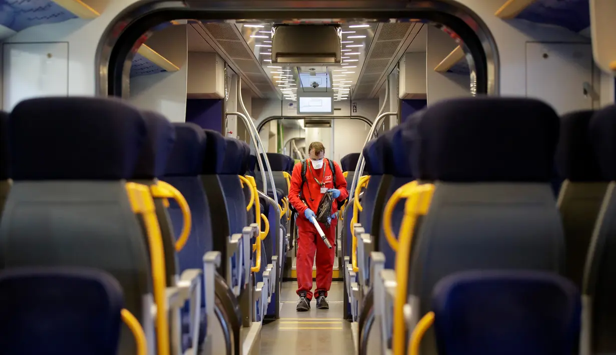 Seorang pekerja membersihkan gerbong kereta regional di stasiun kereta Garibaldi di Milan, Jumat (28/2/2020). Otoritas Italia mengambil langkah-langkah pencegahan penyebaran virus corona dengan menyemprot disinfektan dan membersihkan kereta serta transportasi umum. (AP/Luca Bruno)