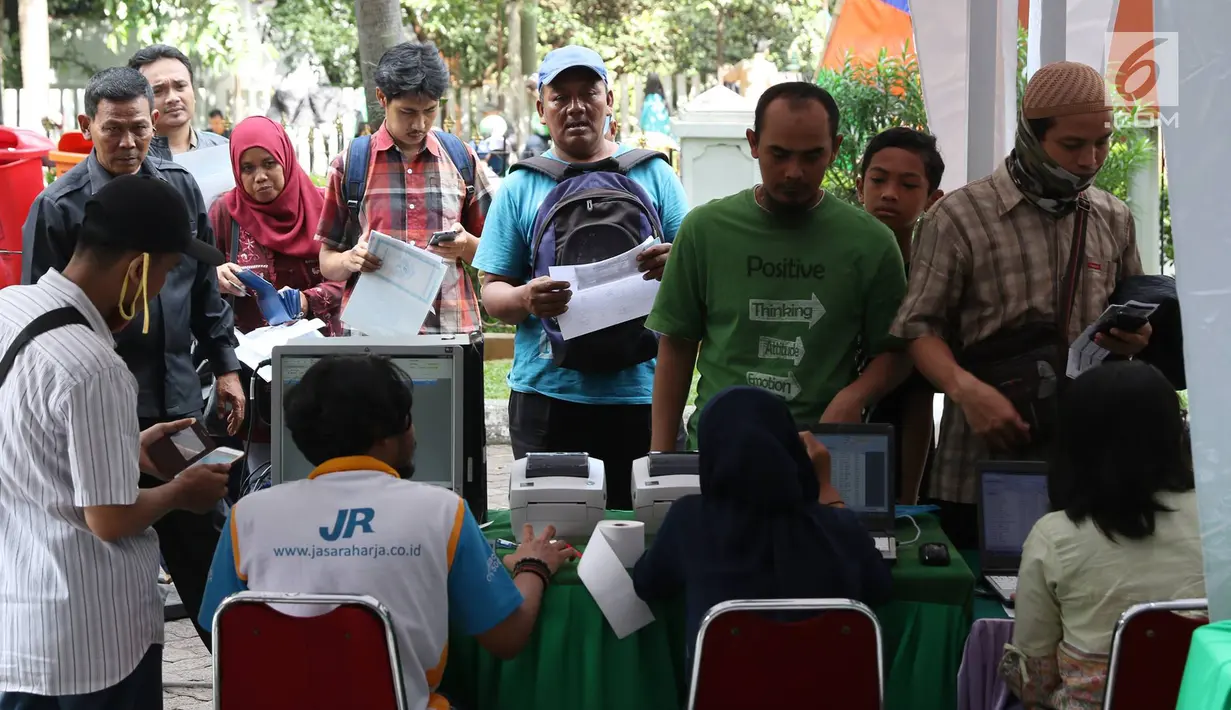Sejumlah orang mengambil nomor antrean untuk verifikasi pendaftaran mudik gratis bersama Jasa Raharja di Jakarta, Rabu (7/6). Mudik gratis Jasa Raharja ini disediakan untuk 31.864 orang dengan 66 kota tujuan di Pulau Jawa. (Liputan6.com/Immanuel Antonius)