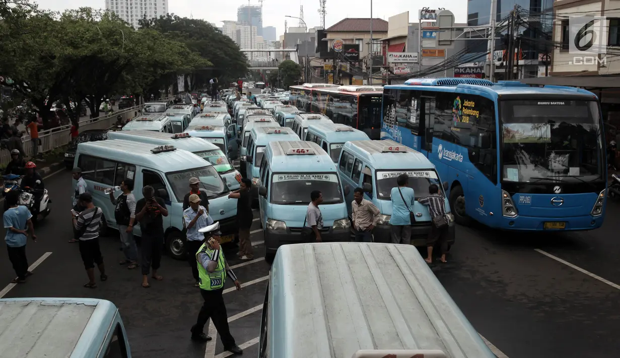 Sopir angkot trayek 44 (Jatinegara-Kampung Melayu-Tebet) memarkirkan kendaraannya saat unjuk rasa di sekitar Stasiun Tebet, Jakarta, Senin (12/2). Demo terkait keberadaan Transjakarta rute Kampung Melayu-Tanah Abang. (Liputan6.com/Arya Manggala)