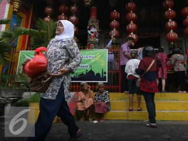Seorang warga membawa sembako yang di bagikan oleh warga keturunan Tionghoa di Klenteng Fuk Ling Miau, Yogyakarta, Jumat (1/7). Pembagian sembako dilakukan sebagai bentuk kepedulian terhadap sesama di bulan ramadan. (Liputan6.com/Boy Harjanto)