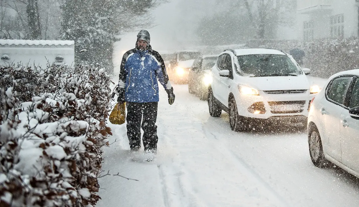 Seorang pria berjalan melewati salju tebal di Aalborg, Denmark, Selasa (27/2). Cuaca dingin di Siberia yang dijuluki "The Beast from the East" membuat suhu di sebagian Eropa menurun. (AFP PHOTO/Scanpix DAN Ritzau SCANPIX/Henning Bagger/Denmark OUT)