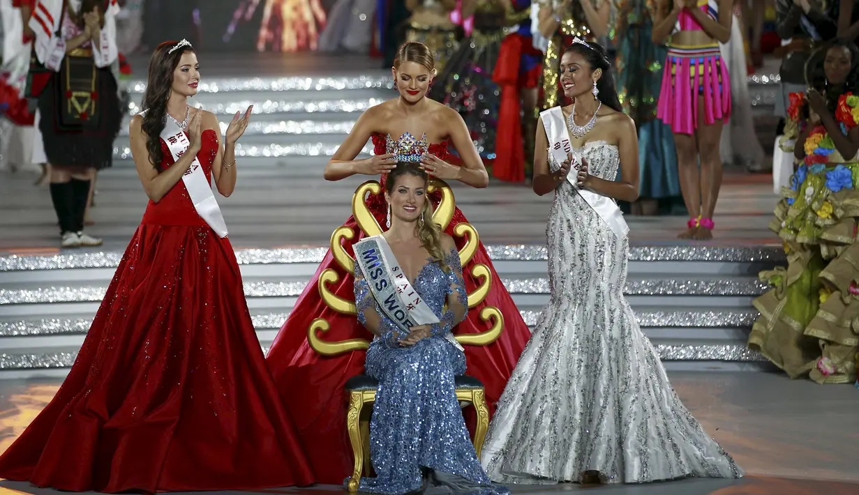 Miss Spanyol, Mireia Lalaguna Royo (duduk) menerima mahkota dari pemenang Miss World 2014 didampingi oleh juara kedua Miss Rusia, Sofia Nikitchuk dan Miss Indonesia,Maria Harfanti (kanan) di Sanya,  Cina, Sabtu (19/12). (REUTERS/Stringer)