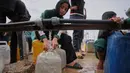 Seorang pemuda Palestina mengambil air di pabrik desalinasi, Khan Younis, Jalur Gaza selatan, Jumat 6 Februari 2026. Pengungsi Palestina di Gaza masih harus berjuang untuk mendapatkan air bersih dan bantuan makanan di dapur umum Khan Younis, Jalur Gaza selatan. (AP Photo/Abdel Kareem Hana)