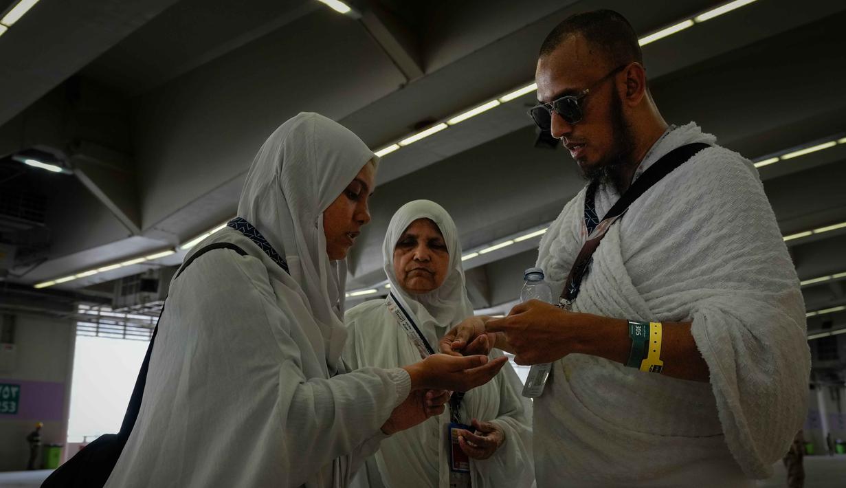 Umat Muslim menghitung kerikil sebelum melempar jumrah sebagai rangkaian ibadah haji di Mina, Arab Saudi, Rabu 27 Mei 2026. (AP Photo/Altaf Qadri)
