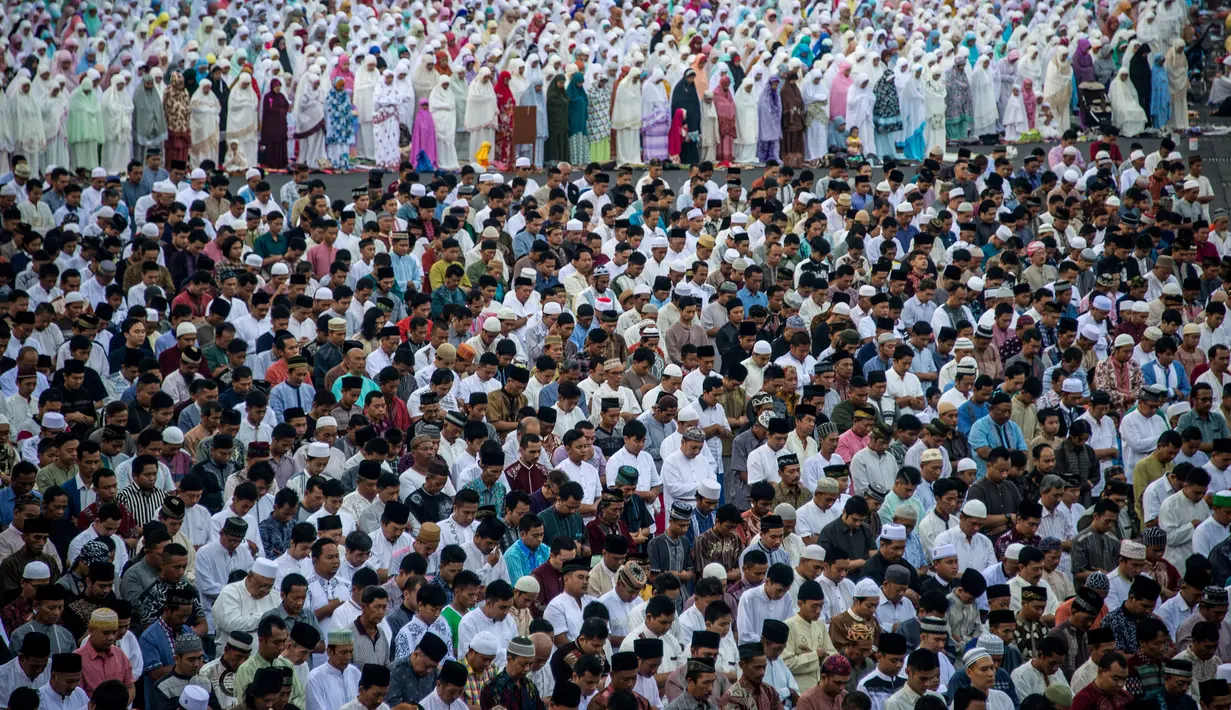 Sejumlah umat muslim melakukan salat Idul Fitri di sekitar masjid di Surabaya (25/6). Pemerintah Indonesia menetapkan 1 Syawal 1438 H pada Minggu (25/6) setelah menunaikan 29 hari ibadah puasa. (AFP Photo/Juni Kriswanto)