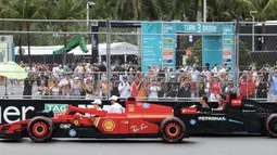 Pembalap Ferrari, Charles Leclerc bersama Lewis Hamilton mengikuti parade pembalap menggunakan mobil lego sebelum balapan Formula 1 GP Miami 2025 yang berlangsung di Sirkuit Autodromo, Miami, Florida, Minggu (04/05/2025) waktu setempat. (AFP/Charly Triballeau)