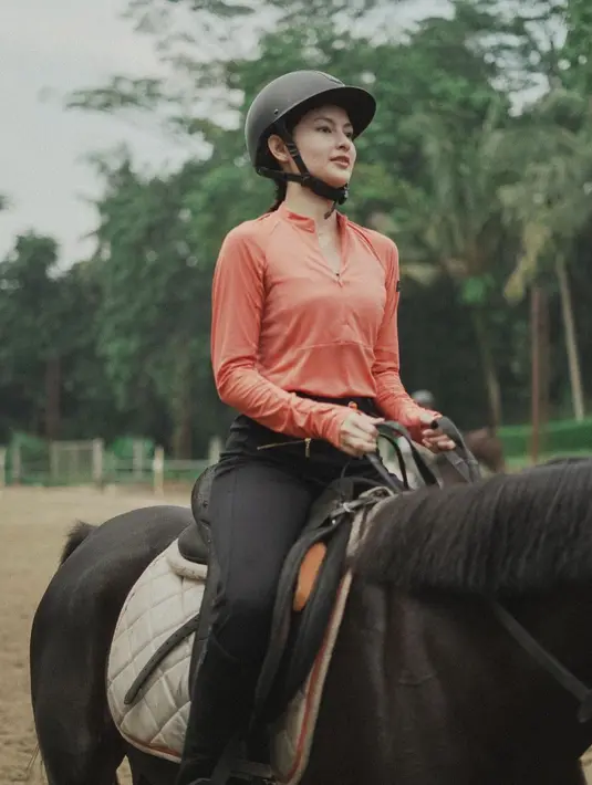 Berjalan pelan, pemain Film Pertaruhan The Series ini fokus kedepan memperhatikan arah kuda berjalan. Clara Bernadeth memegang kendali penuh atas kuda yang ditungganginya. Helm hingga sepatu boat tak boleh ketinggalan bagi aktris berdarah Prancis-Indonesia ini. (Liputan6.com/IG/@clarabernadeth).