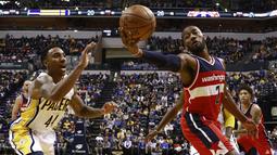 Aksi pemain Washington Wizards, John Wall (2) mengontrol bola saat berduel dengan pemain Indiana Pacers, Jeff Teague (kiri) pada laga NBA basketball game di Bankers Life Fieldhouse, Indianapolis, (19/12/2016). (AP/R Brent Smith)