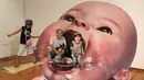 Pengunjung berpose dengan gambar 3D seorang bayi di pameran seni trik 3D karya seniman Jepang Masashi Hattori di Kawasaki, dekat Tokyo, Sabtu, (5/8). (AP Photo / Koji Sasahara)