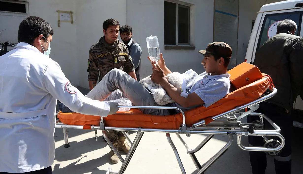 Seorang pria muda ditandu ke rumah sakit setelah serangan bom bunuh diri di dekat Universitas Kabul, Afghanistan, (21/3). Sedikitnya 26 orang tewas akibat serangan bom bunuh diri saat perayaan tahun baru Persia. (AP Photo/Rahmat Gul)