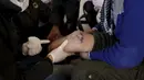 Khamis (kiri) melihat kondisi kaki seorang pria yang di amputasi, kota Maaret al - Numan di provinsi Idlib , Suriah 20 Maret 2016. Daerah ini merupakan daerah konflik yang mana warganya banyak yang menjadi korban. (REUTERS / Khalil Ashawi)