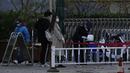 Pengunjung diperiksa oleh penjaga keamanan di pintu masuk Universitas Peking di Beijing, Rabu (16/11/2022). Mahasiswa dan fakultas Universitas Peking tidak diizinkan meninggalkan pekarangan kecuali diperlukan. (AP Photo/Ng Han Guan)