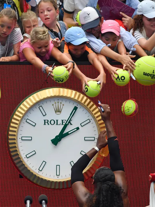 Petenis AS, Serena Williams membubuhkan tanda tangan di bola tenis penggemarnya setelah memenangkan pertandingan putaran kedua Australia Terbuka melawan petenis Swiss, Belinda Bencic di Melbourne, Rabu (18/1). (AP Photo/Andy Brownbill)