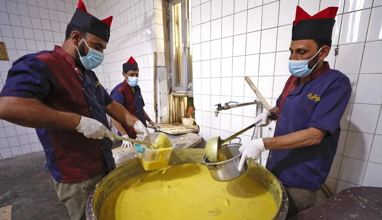 Para juru masak menyajikan makanan berbuka puasa kepada yang membutuhkan dari dapur di Masjid Muslim Sunni Abdel Kader al-Kilani di Baghdad, Irak, 19 April 2021. Kegiatan ini berlangsung selama bulan suci Ramadhan. (AHMAD AL-RUBAYE/AFP)