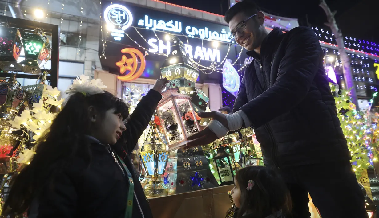 Seorang pedagang Palestina memajang lentera tradisional "fanous" di Hebron di Tepi Barat yang diduduki pada 27 Maret 2022. Fanous merupakan lentera untuk dekorasi yang digunakan merayakan awal bulan suci Ramadan. (HAZEM BADER / AFP)