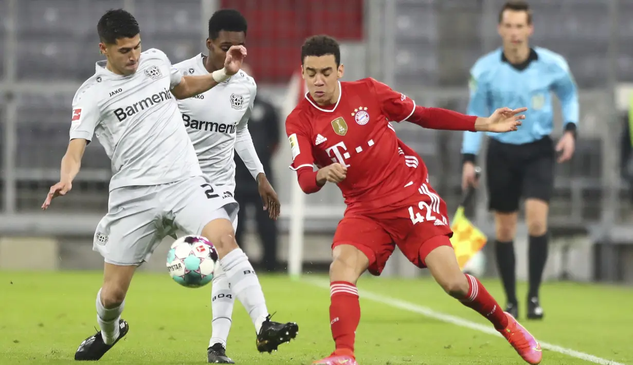 Pemain Bayer Leverkusen Mitchell Weiser (kiri) berebut bola dengan pemain Bayern Munchen Jamal Musiala pada pertandingan Bundesliga di Stadion Allianz Arena, Munchen, Jerman, Selasa (20/4/2021). Bayern Munchen menang 2-0. (AP Photo/Matthias Schrader, Pool)